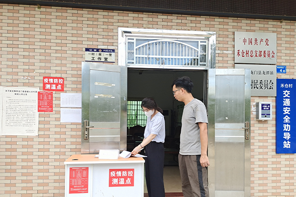 图为龙门县纪委监委督查组到村委检查疫情防控落实和假日值班值守情况（龙门县纪委监委  张海敏摄）.jpg