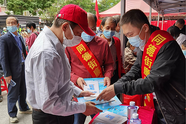 图为同德街纪工委工作人员向群众派发实名举报宣传材料.jpg